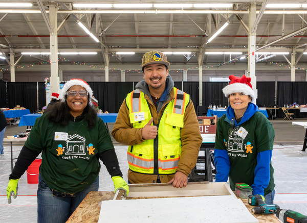 Deck the Walls volunteers smiling at the camera with Santa hats on
