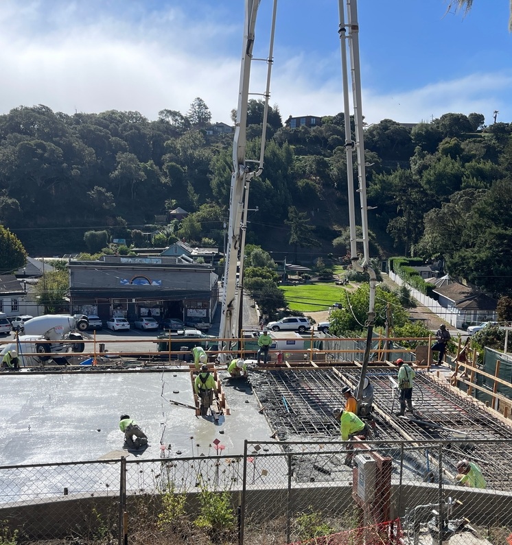 Construction workers pouring concrete at site in Bolinas.